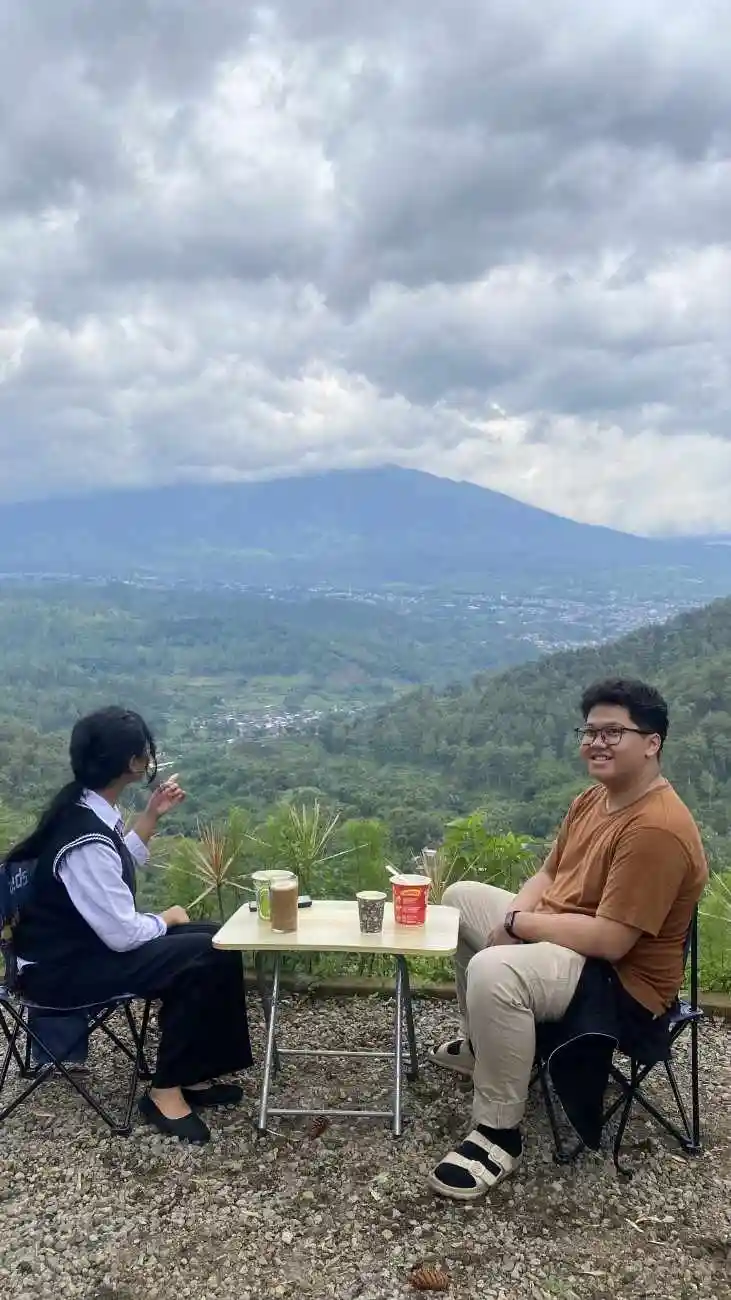 Keceriaan berkumpul sambil bermain di area kemping yang luas dengan pemandangan pegunungan yang asri