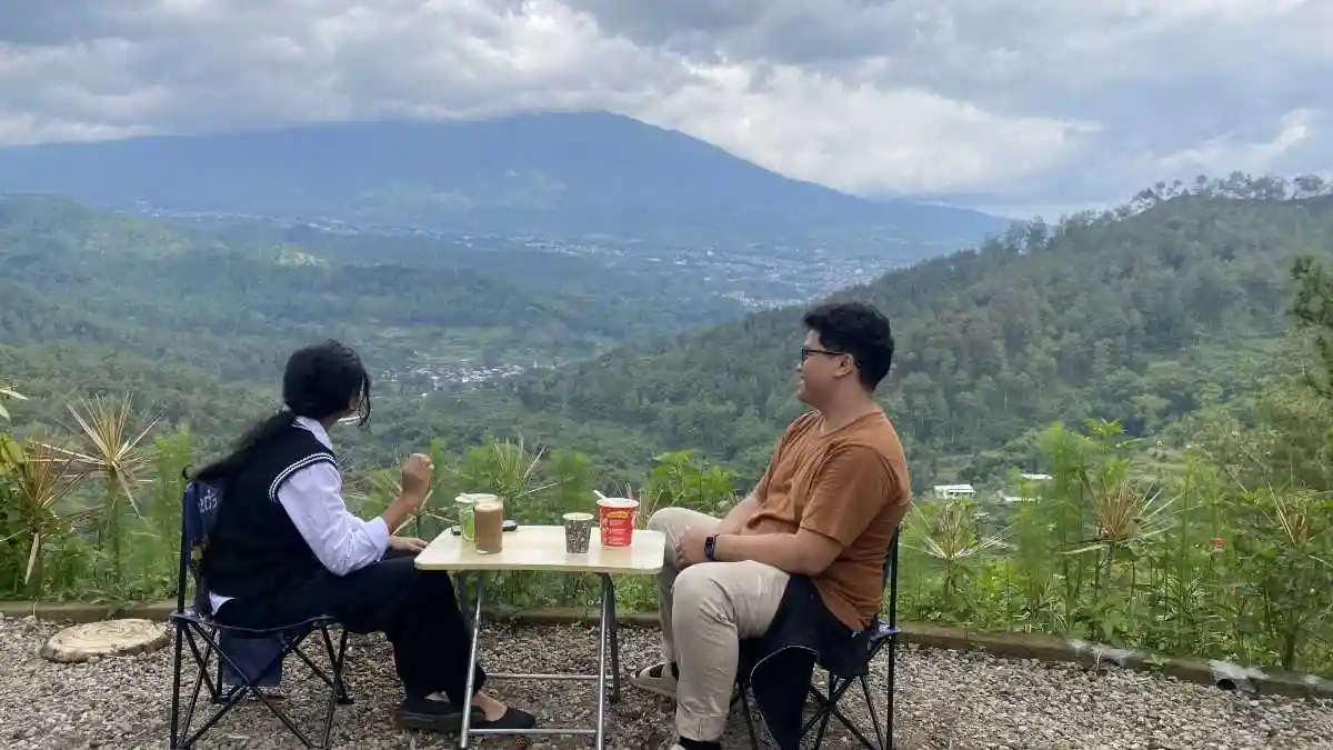 Area berkumpul dengan kursi camping dan view panorama Malang Raya dari Batu Sunrise Camp — spot city light terbaik untuk Makrab mahasiswa
